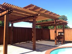 a wooden pergola next to a swimming pool