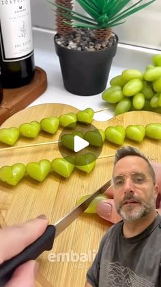 a man is cutting grapes with a knife