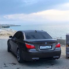 a black car parked next to the ocean