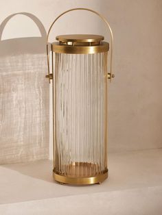 an old fashioned lantern is sitting on a white surface with a shadow cast in the background