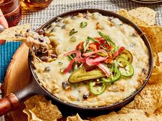 a skillet filled with tortilla chips topped with veggies and sauce