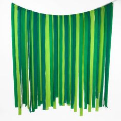 green streamers hanging from the ceiling in front of a white wall