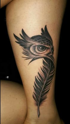 a woman's leg with a feather tattoo on it and an eye in the center