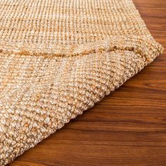 a close up view of a rug on a wooden floor with wood grained surface