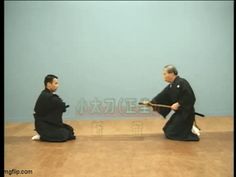 two men sitting on the floor in front of a blue wall with words written above them