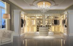 an elegant walk - in closet with chandelier and white furniture is lit up