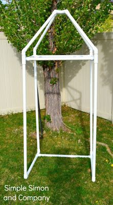 a white garden trellis next to a tree in the yard with text overlay that says simple simon and company