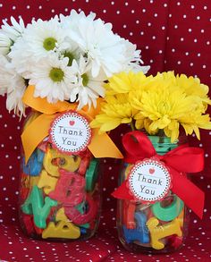 two mason jars filled with yellow flowers and thank you notes on the top one is decorated with red ribbon