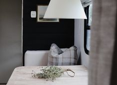 a table with a plant on it in front of a couch and lamp hanging from the ceiling