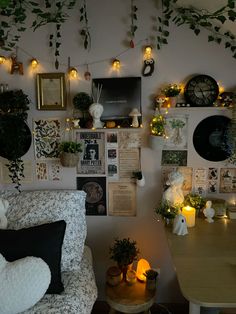 a living room filled with lots of plants and pictures on the wall next to a couch