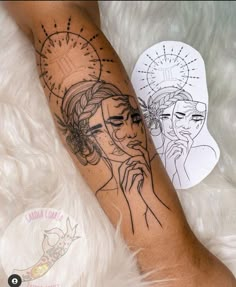 a woman's leg with a tattoo on it and an image of jesus behind her