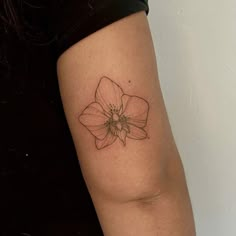 a small flower tattoo on the arm