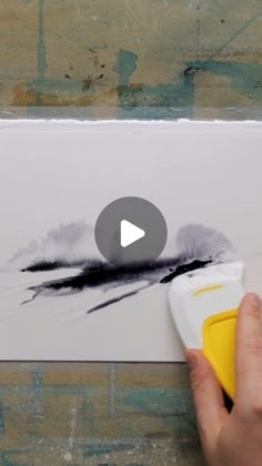 someone is using a video to paint a piece of paper with black and white ink