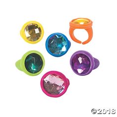 four different colored plastic rings on a white background