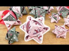 several origami ornaments are arranged on a wooden table with ribbons and bows in the shape of stars