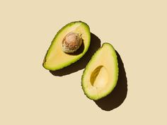 an avocado cut in half on a beige background