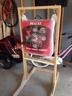 a red pillow sitting on top of a wooden stand next to other items in a garage