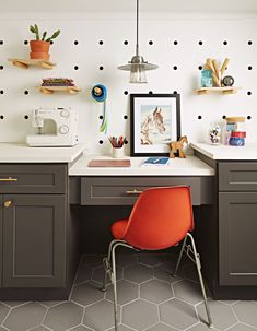 an orange chair sitting in front of a desk with a sewing machine on top of it