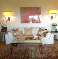 a living room filled with lots of furniture and decor on top of a carpeted floor