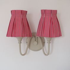 two red and white lamps mounted on a wall