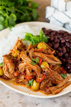 the best mexican food in ropa vieja is served with beans, rice and cilantro