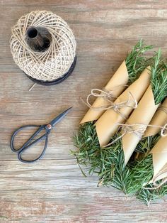 some cones are tied up with twine and sprig of grass on the table