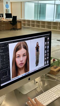 a computer screen with a woman's face on it and an apple keyboard in the foreground