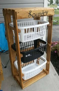 three baskets are stacked on top of each other in front of a wooden stand with the word laundry written on it