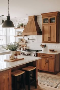 a kitchen with wooden cabinets and an island in front of a stove top oven next to two stools