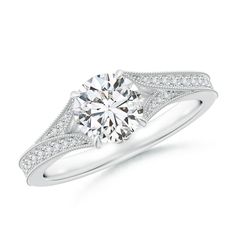 a white gold engagement ring with diamonds on the sides and an intricate band around it