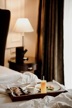 a tray with food on top of a bed