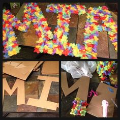 the letters are made out of paper and colored tissue pom poms on the floor