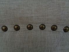 four brass knobs on the back of a chair