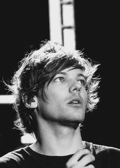 black and white photograph of a young man looking up at something in the air with his eyes closed