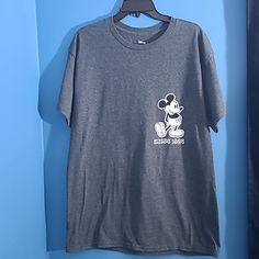 a mickey mouse t - shirt hanging on a blue wall