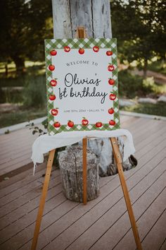 a welcome sign sitting on top of a wooden easel in front of a tree