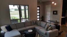 a living room filled with lots of furniture next to a large open floor plan window