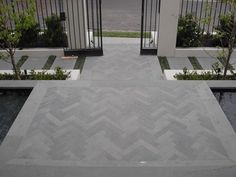 the entrance to a house with an open gate and stone flooring in front of it