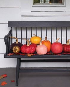 a bench with pumpkins and leaves on it