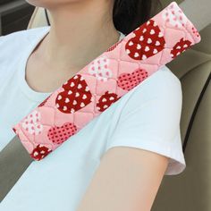 a woman wearing a car seat belt with hearts on it