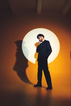 a man standing in front of a wall with a shadow on it