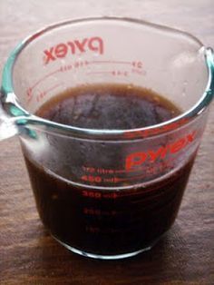 a measuring cup filled with liquid on top of a wooden table