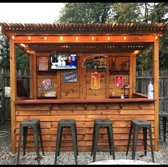 an outdoor bar with three stools under it