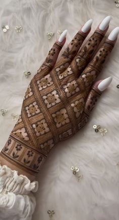 a woman's hands with hennap and white nails