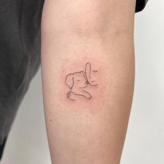 a woman's arm with a small dog tattoo on the left side of her leg