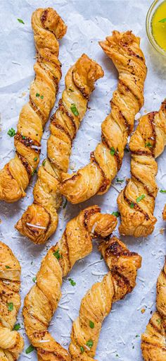 several skewers of food sitting on top of a piece of paper next to a cup