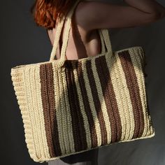 Each thread carries the soft texture and color of the beach sands, while the brown asymmetric line details add a dose of modernity and elegance to the bag. The wide shoulder design provides the user with a sense of freshness and comfort, while also adding grace to your style. This bag is not just an accessory, but a piece that carries the tranquility and beauty of nature. The brown asymmetric line details in the shades of beach sands reflect the calmness of nature and the serenity of the shore i Beige Rectangular Summer Beach Bag, Beige Rectangular Straw Bag For Beach Season, Beige Handwoven Bag For Beach Season, Handwoven Beige Bag For Beach Season, Brown Beachy Straw Bag For Daily Use, Beachy Straw Bag In Sand Color, Handwoven Beige Bag For Vacation, Beige Woven Beach Bag For Vacation, Rectangular Cream Shoulder Bag For Beach