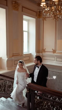 the bride and groom are walking down the stairs