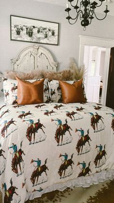 a bedroom with a bed, chandelier and pictures on the wall above it