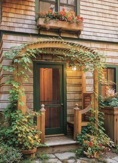 an outside view of a house with flowers and plants on the front door, along with potted plants